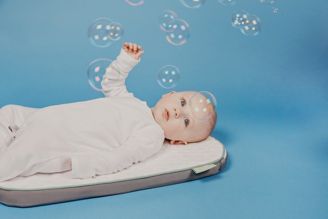 babyinwhiteonesielyingonwhitebed